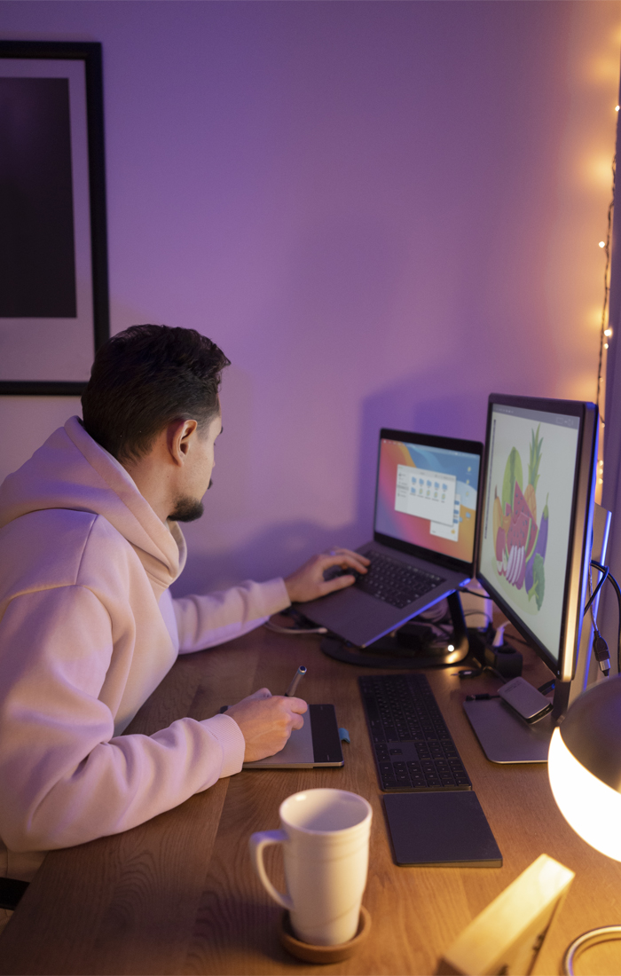 designer working with multiple screens and a drawing tablet